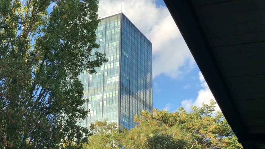 Modern skyscraper office building framed by trees in Berlin
