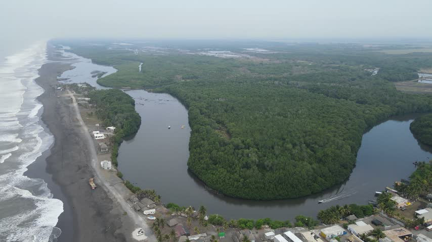 Aerial view of coastal mangrove forest, river mouth and black sand coastline in Guatemala.