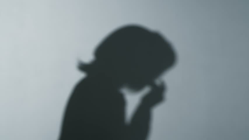 Silhouette of a woman coughing
