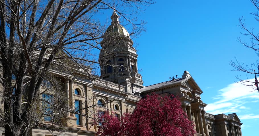 Top of Wyoming State Capitol building seen behind trees