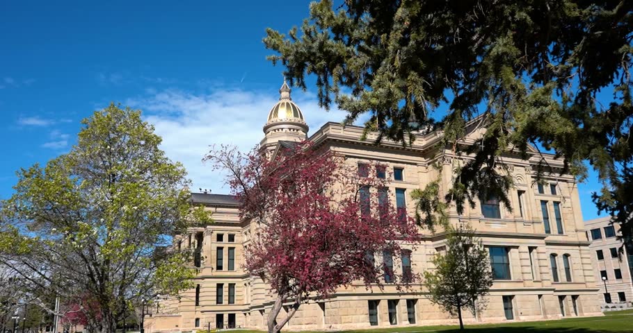 Side view of Wyoming State Capitol building behind trees