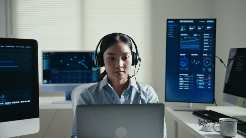 Professional female stock trader wearing a headset while consulting with a client in the office