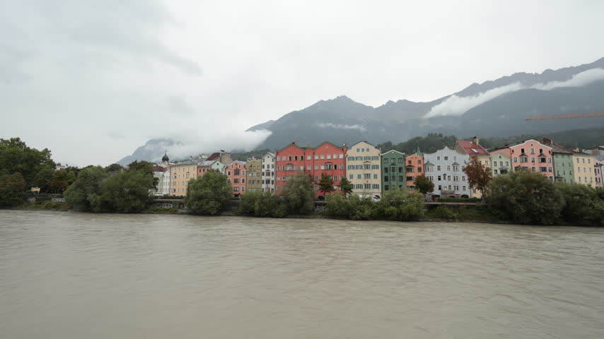 City scape in Innsbruck city center with beautiful houses, river Inn and Tyrolian Alps, Austria, Europe . High quality 4k footage