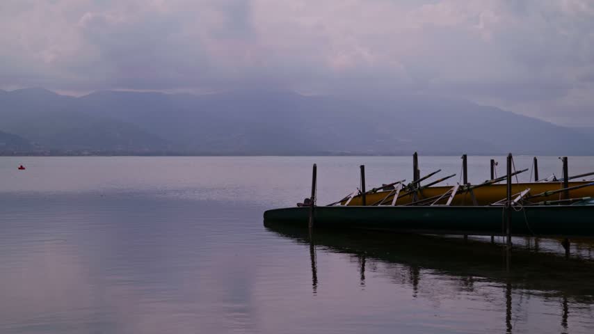 Two Large Canoes Tied to Dock on Foggy Lake Sapanca with Mount Kartepe in Background at Sunrise
