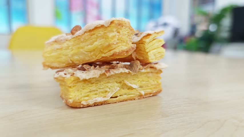French Jesuite puff pastry with almonds on a light wooden table.