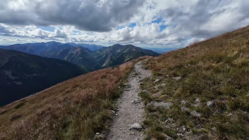 Walking Along a Mountain Ridge Hiking Trail with Scenic Alpine Panorama