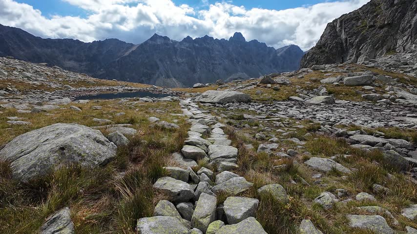 Stone Hiking Path Leading Across Rocky Alpine Mountain Valley Toward Peaks