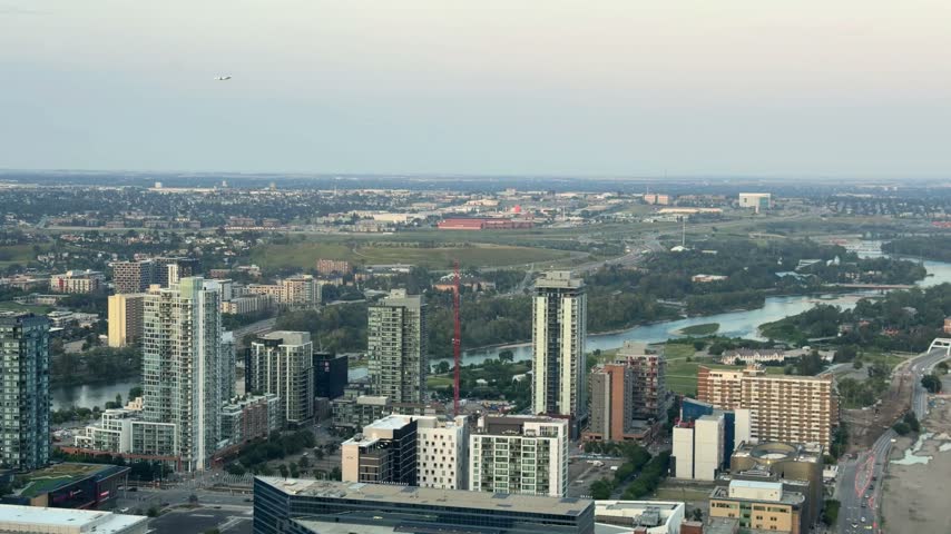 Aerial view of Calgary with high-rise condo towers, the Bow River and the city stretching to the horizon in Alberta, Canada, an urban cityscape on a hazy day.