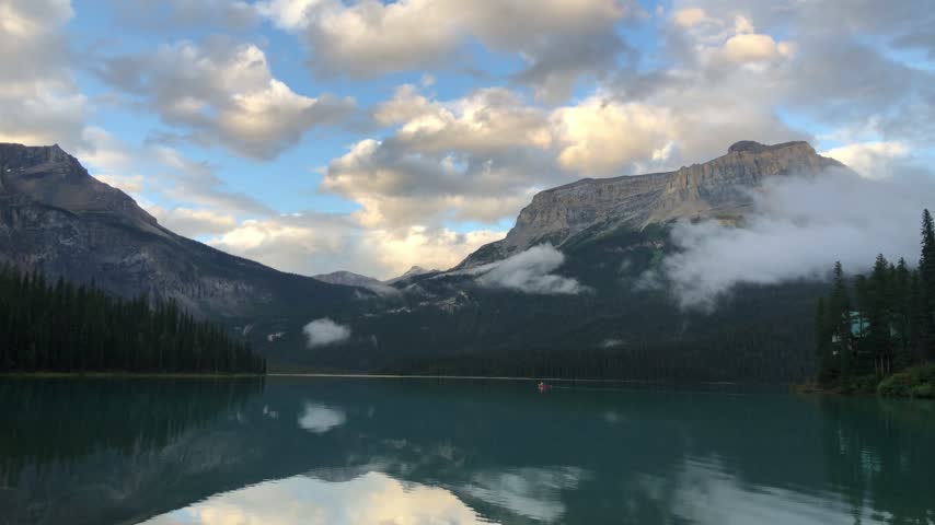 Mountains and evening clouds reflected in calm Emerald Lake, Canada.