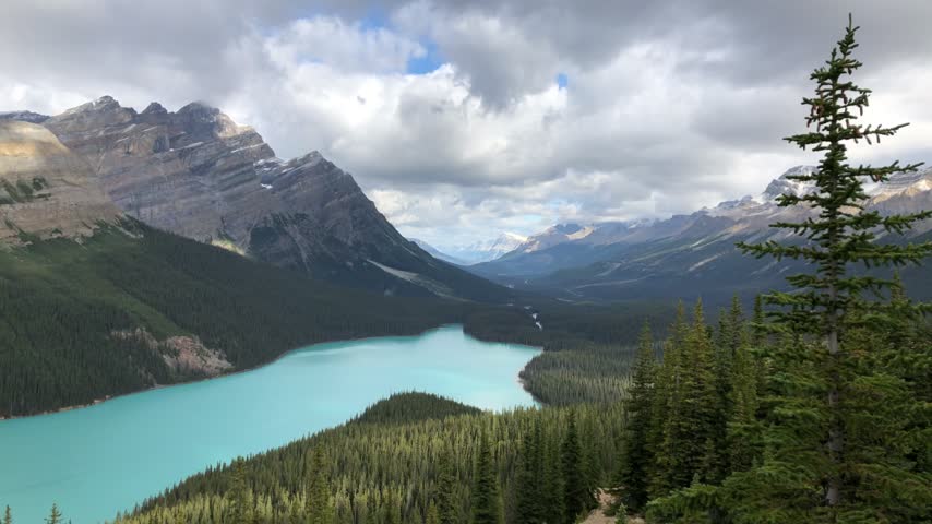Cloud shadows moving across the slopes above turquoise Peyto Lake, Canada.