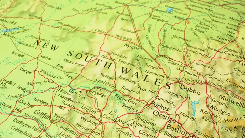 Australia, New South Wales – sliding camera view across a printed physical map toward Sydney and Canberra