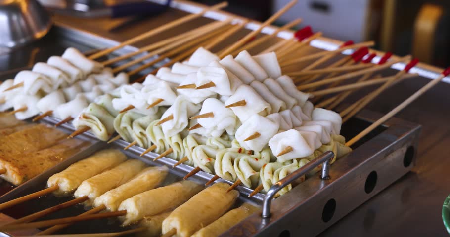Eomuk odeng, assortment of Korean fish cake skewers on display at a street food stall in Jung-gu, Busan, Yeongnam, South Korea, white, green and fried varieties on bamboo sticks at a night market