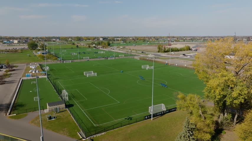Aerial view of a soccer fields next to a road with traffic