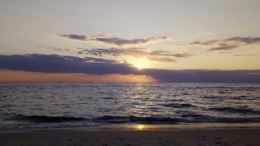 Sun shining in scenic clouds at seaside with gentle waves