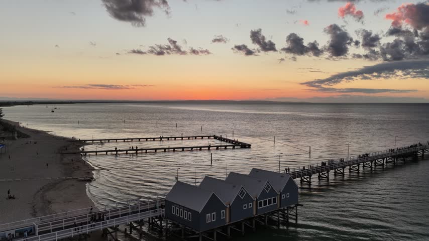 Drone footage of the timber jetty at Busselton in golden evening light, Western Australia. Warm light spreads across a glassy bay. Filmed in the last light of the day.