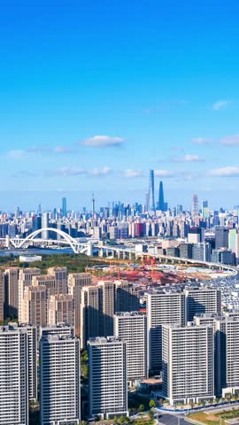An aerial view of the magnificent cityscape in Shanghai, China, featuring the Nanpu Bridge and the stunning skyscraper skyline under a clear sky.