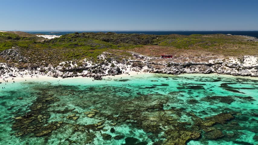 Drone view over the coastal heath and reef of Rottnest Island, Australia. Swell breaks white along an exposed section of reef. The island sits 19 kilometres off the Western Australian coast.