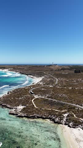 Aerial drone view of the limestone coastline on Rottnest Island, Western Australia. Low scrub runs to the edge of pale limestone rock. Rottnest is a car free A-class reserve off Perth.