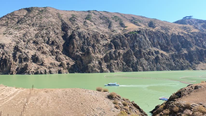 Boat Cruising on a Green Lake Below, Xinjiang Province, China, Asia