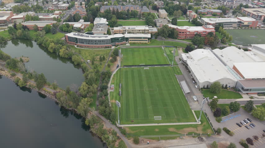 College soccer field and athletic facilities in Spokane, Washington, with campus buildings, green space and the Spokane River nearby.