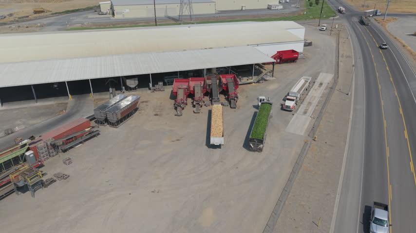 Onion processing facility in Boardman, Oregon, with bulk produce trailers, agricultural equipment, storage buildings, trucks and commercial food-manufacturing operations.