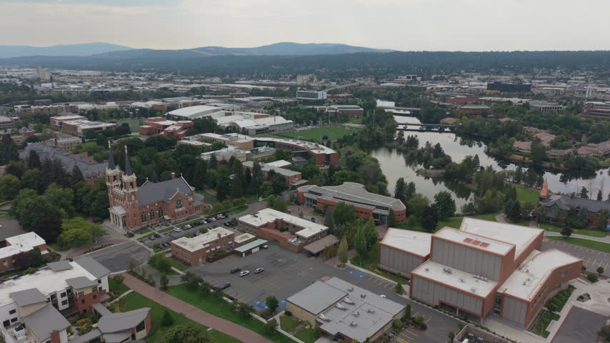 Private University in Spokane, Washington. Slow drone backwards shot showing church and campus buildings.