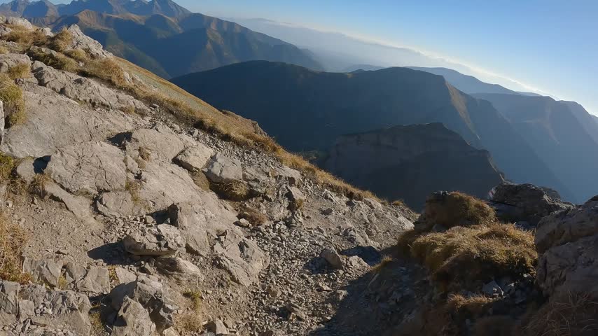 Dry highland grass surrounds a rocky trail on the route from Krzesanica to Ciemniak