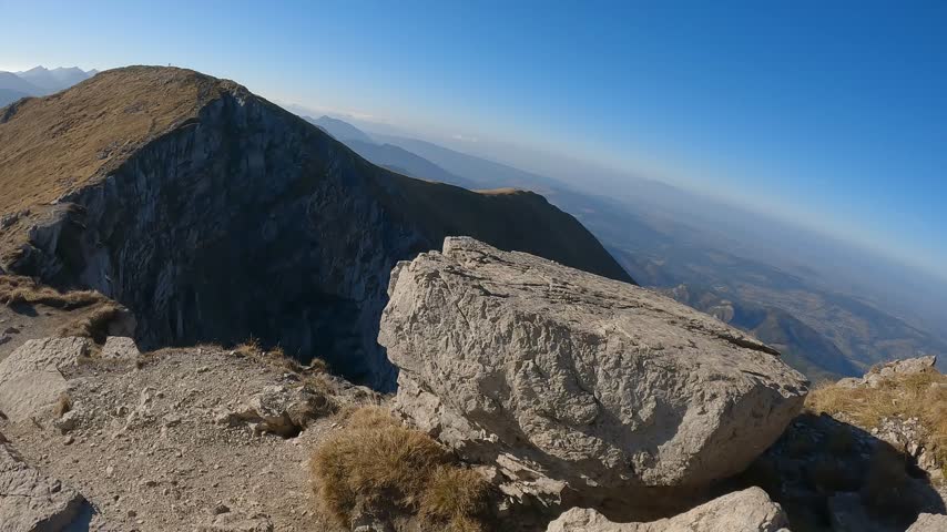 Dry highland grass surrounds a rocky trail on the route from Krzesanica to Ciemniak