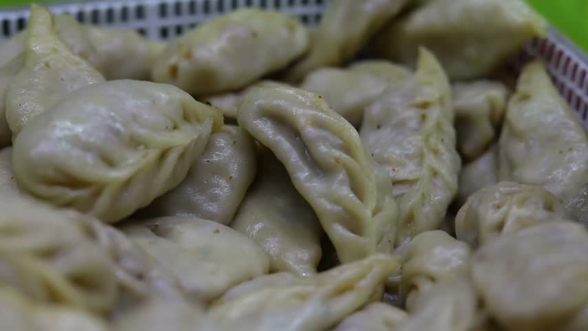 Momo or dumplings filled with vegetables or chicken inside and served with spicy red chilli sauce
