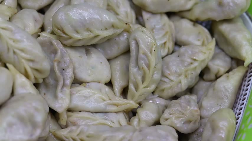 Momo or dumplings filled with vegetables or chicken inside and served with spicy red chilli sauce