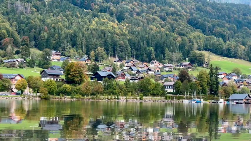 Beautiful alpine landscape of grundlsee lake with a tranquil village reflecting on the clear mountain water in salzkammergut, austria