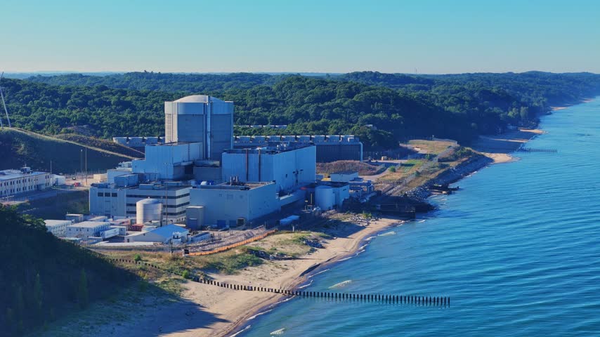 Palisades nuclear power plant located on the shoreline of Lake Michigan in wide establishing shot