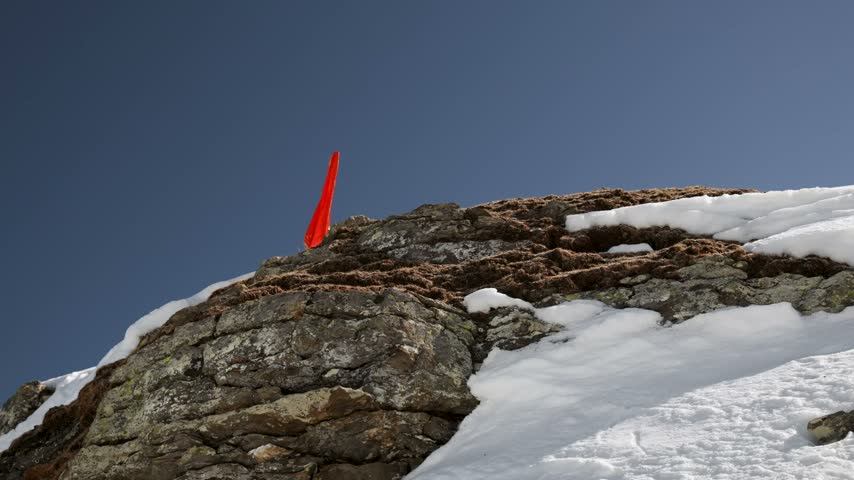 Hiker walking in With Arms Raised celebrating Snowy Mountain Summit
