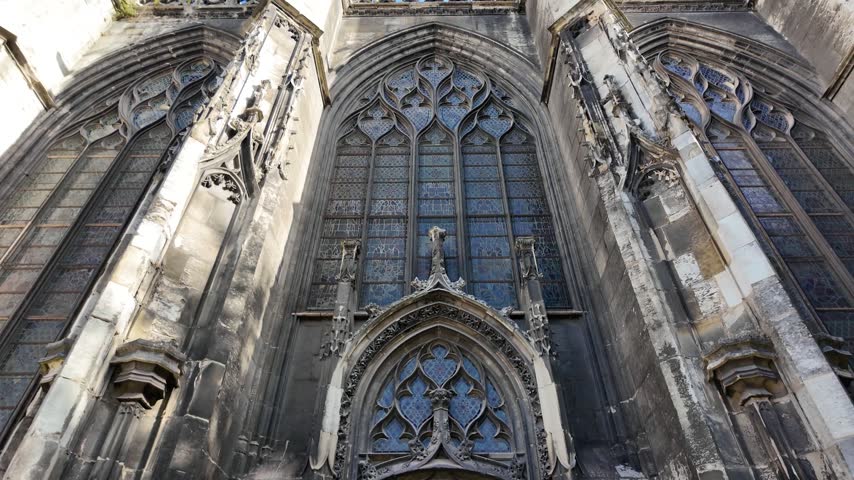 Upward view of Abbatiale Saint-Ouen in Rouen, France showing ornate Gothic tracery, carved stonework, pointed arches and tall stained glass windows