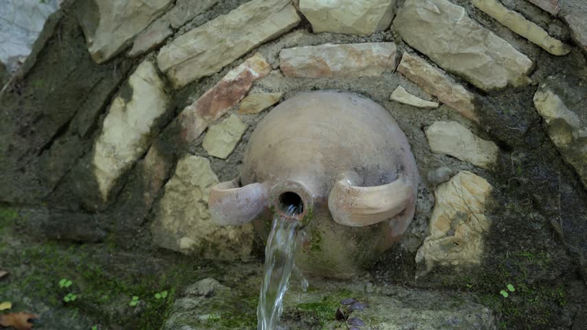 Stone spring in the forest with crystal clear water
