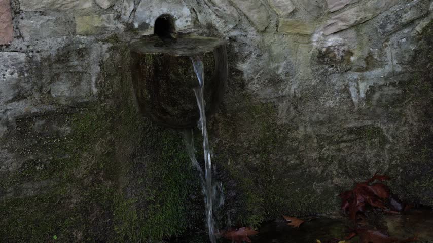 Stone spring in the forest with crystal clear water
