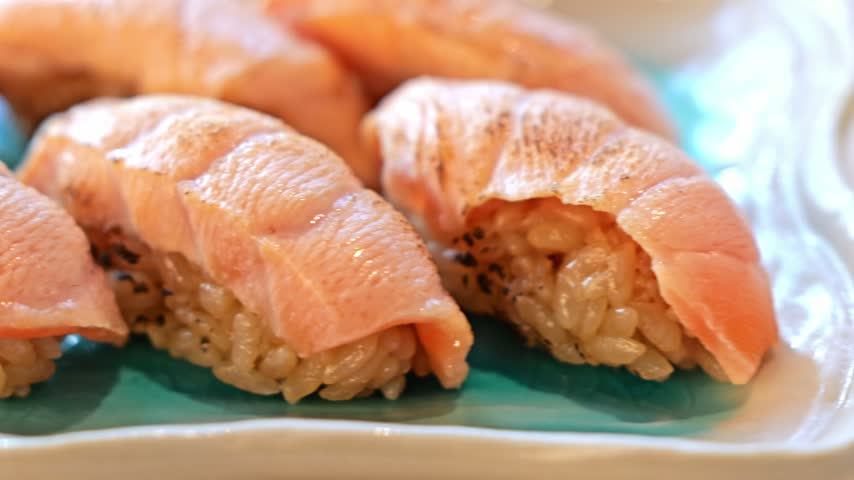 Salmon Sushi Closeup with Rice on Green Plate, Japanese Seafood Meal Served on Ceramic Plate