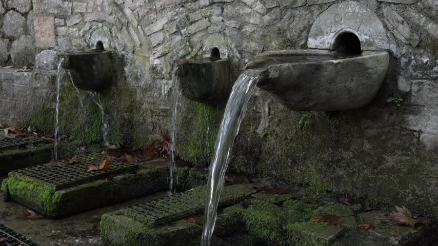 Stone spring in the forest with crystal clear water

