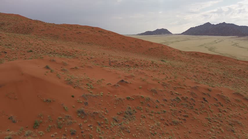 A panorama of sand dunes at sunset. Desert landscape, cloud shadows on the dunes