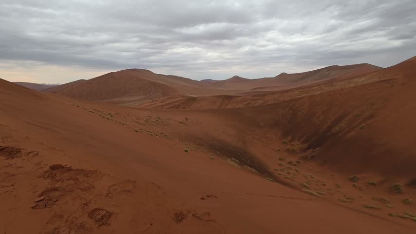 A panorama of sand dunes at sunset. Desert landscape, cloud shadows on the dunes