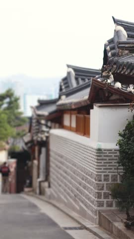 Bukchon Hanok Village in Gahoe-dong, Jongno-gu, Seoul, South Korea, street with traditional Korean hanok houses, giwa tiled roofs and white walls in a narrow alley on a sunny spring day