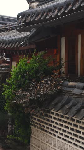Bukchon Hanok Village in Gahoe-dong, Jongno-gu, Seoul, South Korea, street with traditional Korean hanok houses, giwa tiled roofs and white walls in a narrow alley on a sunny spring day