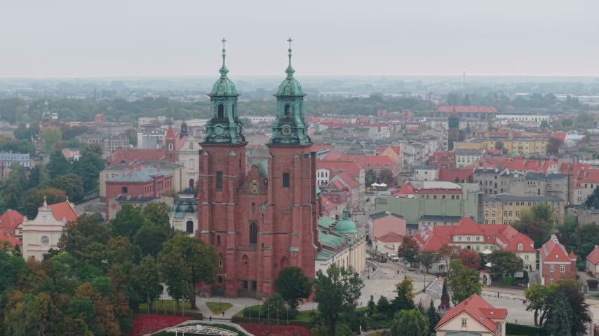 Slow Drone Pullback Revealing Gniezno Cathedral and Historic Cityscape Among Autumn Trees, Poland