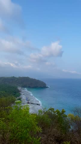 Ocean waves crashing against volcanic coastal cliff in Bali
