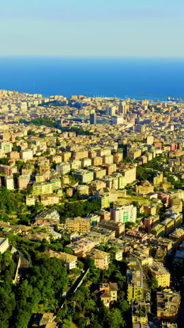 Vertical video. Genoa, Italy. A sweeping aerial view captures the dense urban fabric of one of the Mediterranean