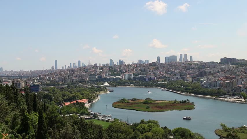 Panoramic view of Istanbul, Turkey, small island in Bosphorus, surrounding parkland and city skyline stretching across hills under bright sky. Travel, sightseeing and urban landscape background
