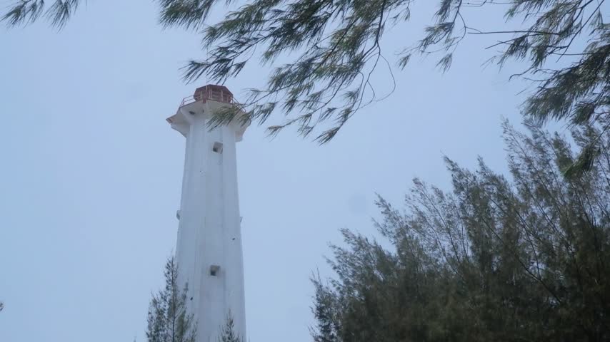 Lighthouse tower viewed from below with the sky in the background.