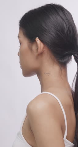 Asian model looking back over her shoulder at camera. She poses gracefully showing clean skin.