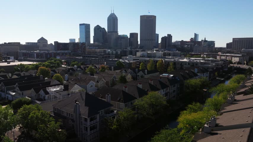 Downtown Indianapolis skyline and residential condo home apartment buildings with the Central Canal, aerial establishing ascend