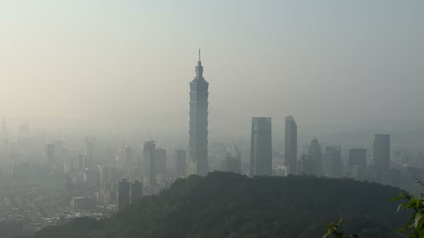 Telephoto view of Taipei 101 and Xinyi district skyscrapers shrouded in haze at sunset, Taipei, Taiwan